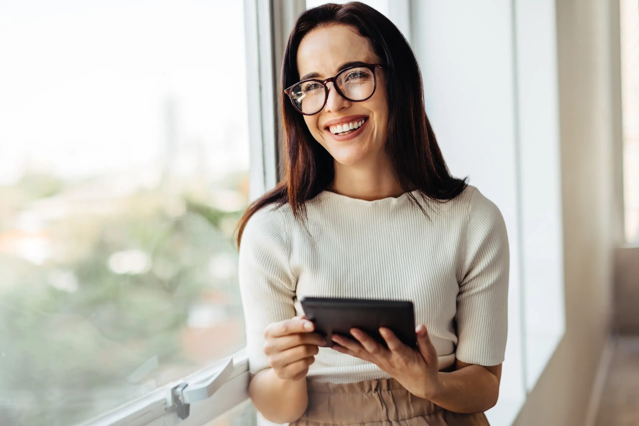 Smiling woman using a tablet, representing easy online dental appointments and patient convenience