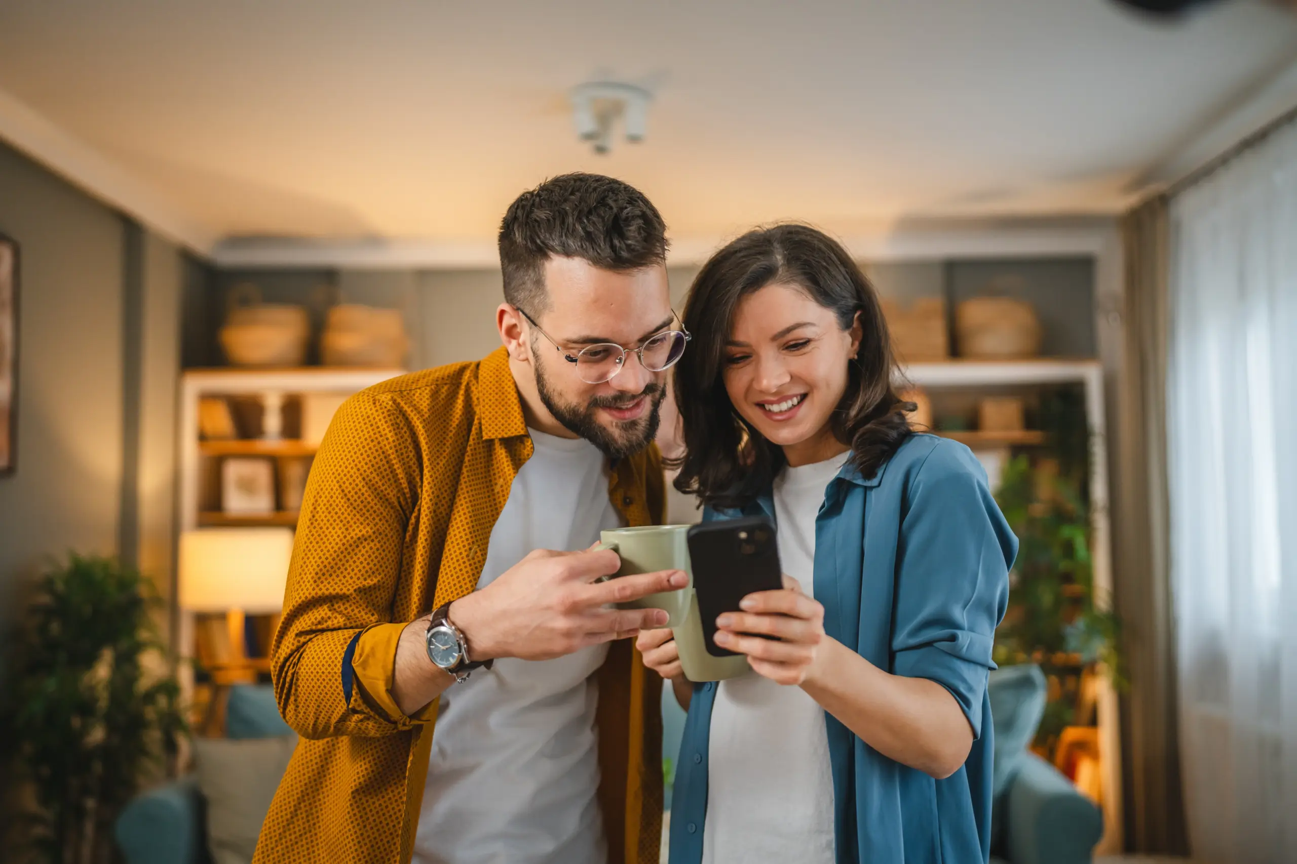Happy couple using a smartphone together, representing booking dental visits and patient communication