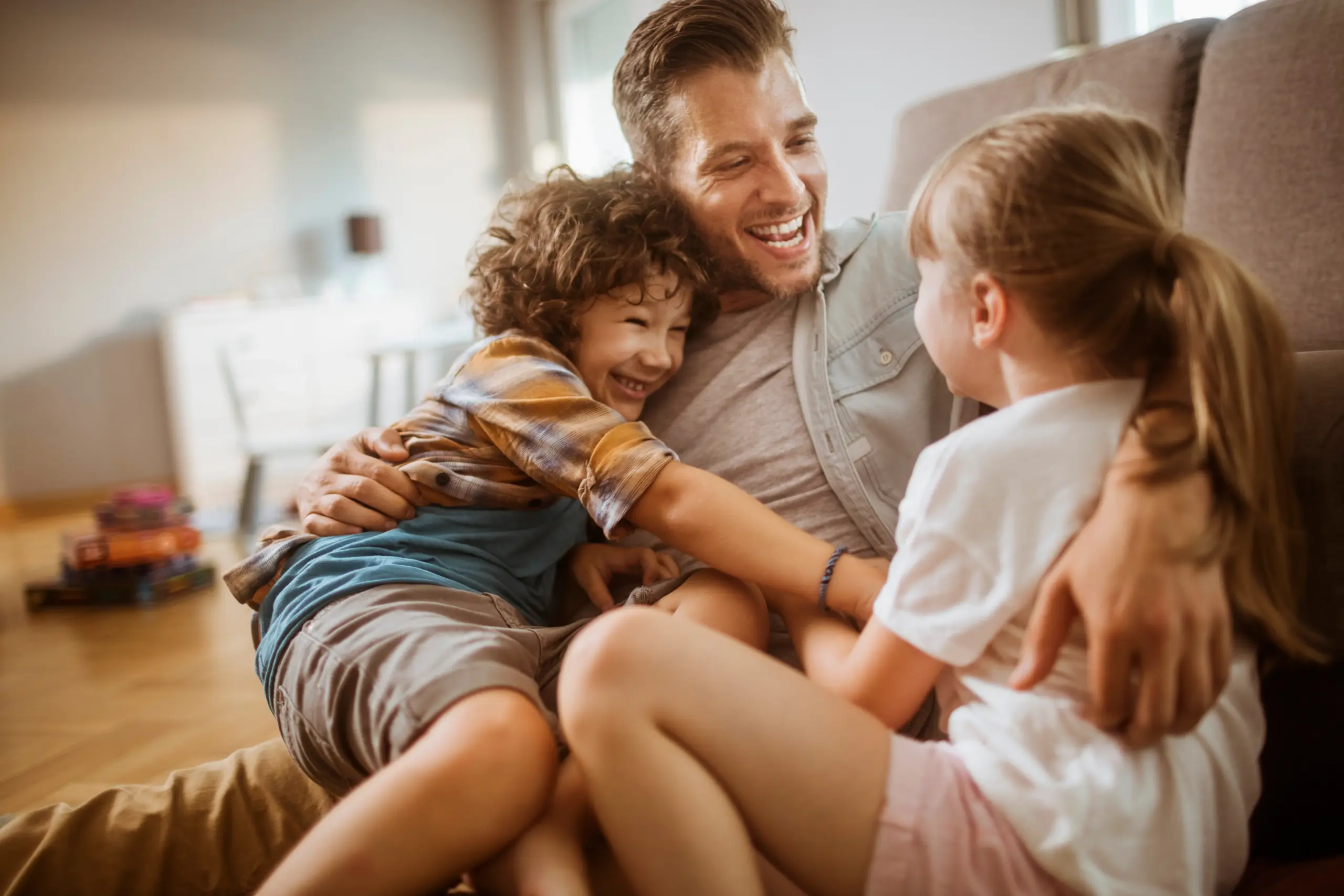 Father playing with children at home, highlighting family-focused dental care and healthy smiles