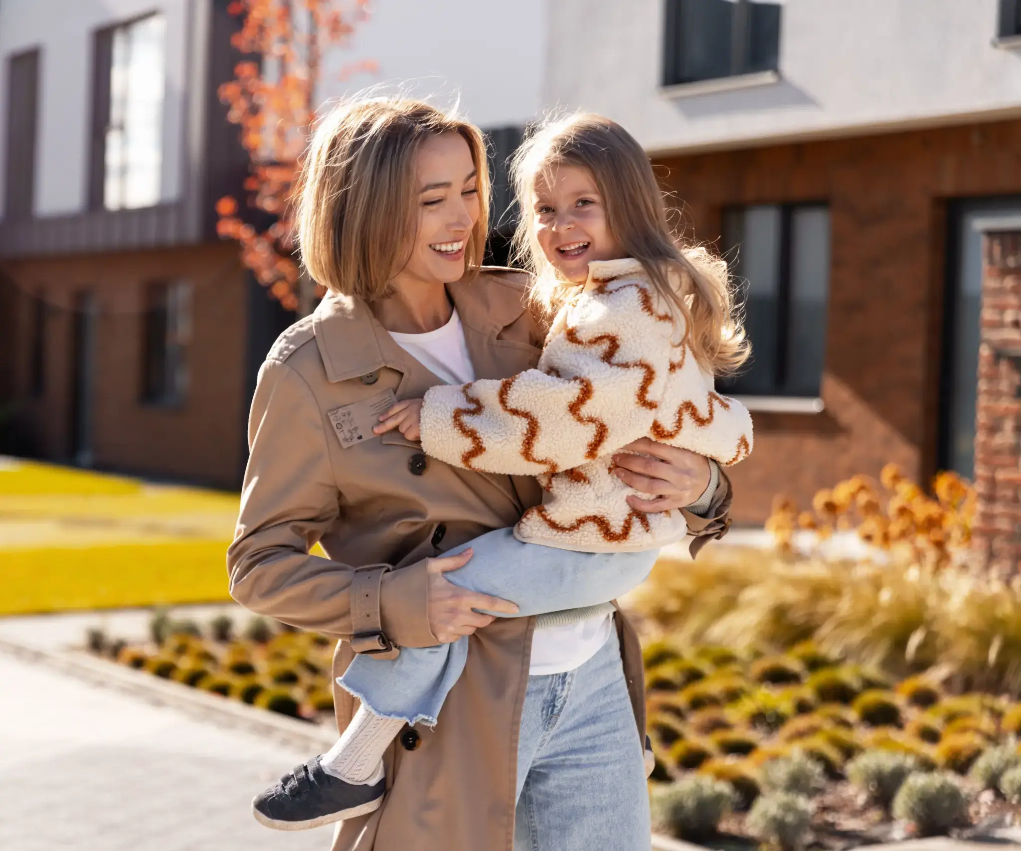 Mother holding child outside home, representing caring family dentistry in Chambersburg, PA